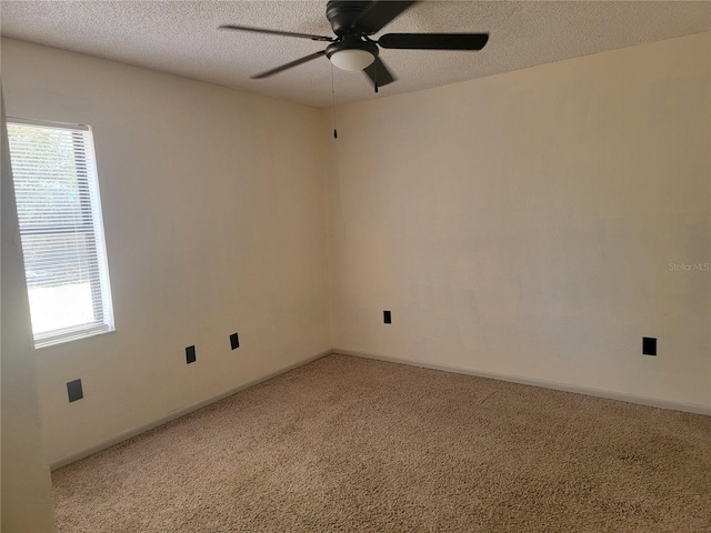 spare room featuring a textured ceiling, ceiling fan, and light carpet