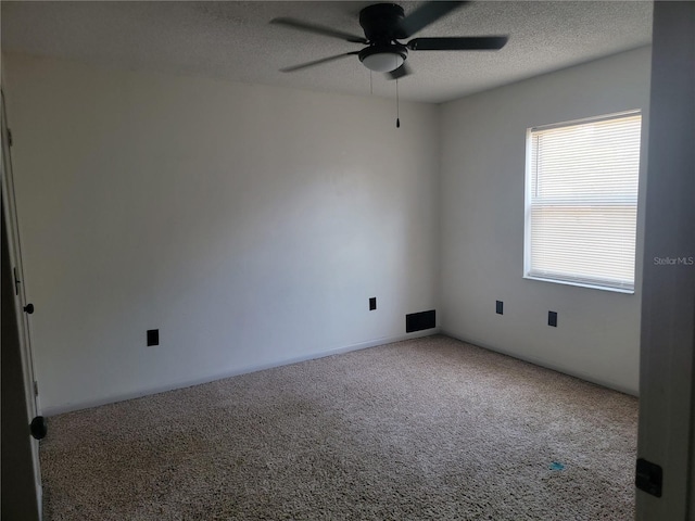 carpeted empty room with a ceiling fan and a textured ceiling