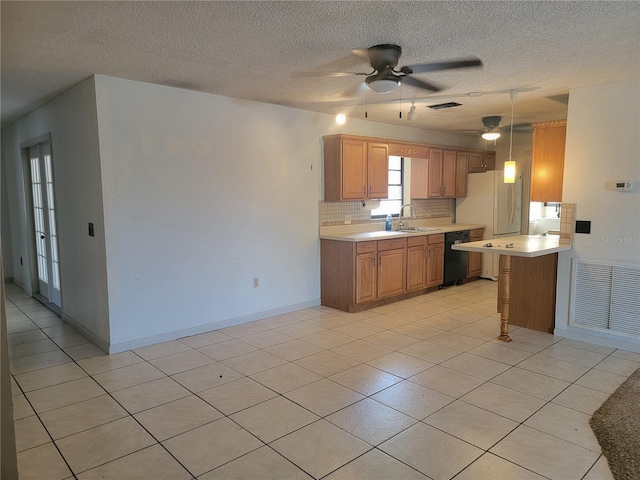 kitchen featuring a sink, light countertops, black dishwasher, and visible vents