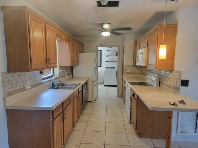 kitchen with backsplash, a sink, light tile patterned floors, washer / dryer, and white appliances