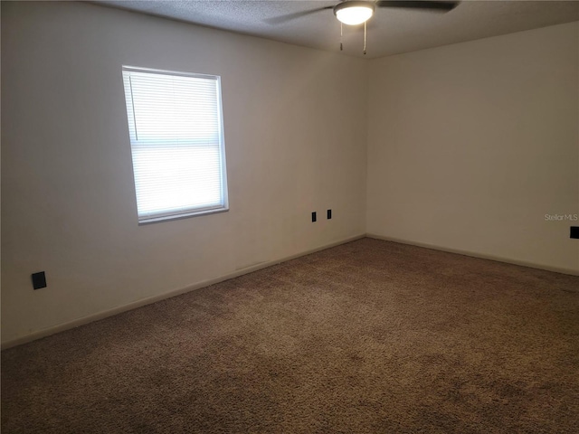 spare room with baseboards, carpet flooring, and a ceiling fan