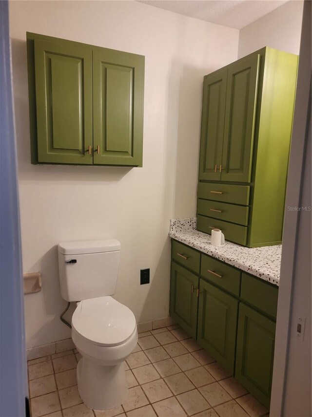 bathroom featuring baseboards, tile patterned flooring, vanity, and toilet