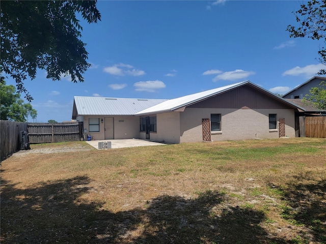 back of house featuring a fenced backyard, stucco siding, a lawn, and a patio area