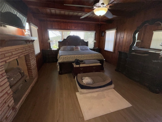 bedroom featuring wooden walls, wooden ceiling, beam ceiling, and wood finished floors