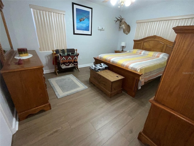 bedroom with baseboards and wood finished floors