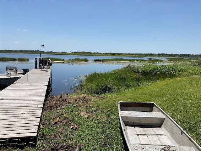dock area featuring a lawn and a water view