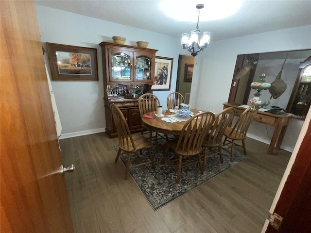 dining room with baseboards, a chandelier, and wood finished floors
