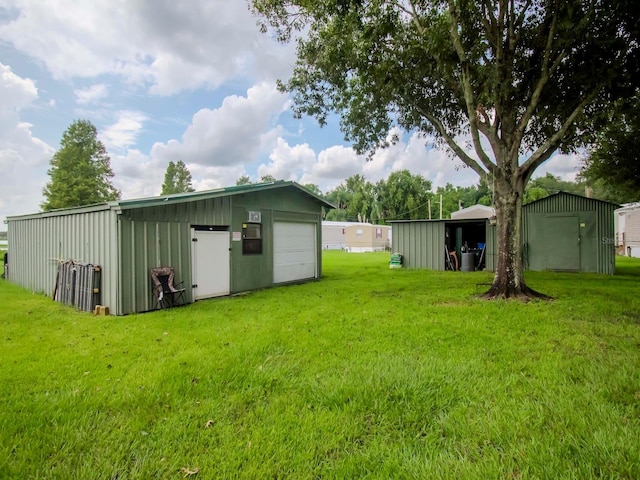 view of yard featuring a garage, an outdoor structure, and a pole building