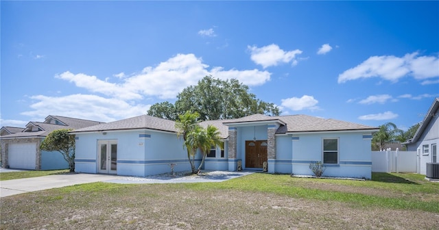 ranch-style home featuring central AC, fence, a front yard, stucco siding, and french doors