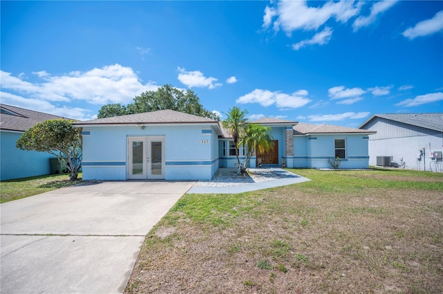 603 Reflections Loop, Winter Haven, FL 33884 - view of front of home with french doors, a front lawn, central air condition unit, driveway, and stucco siding