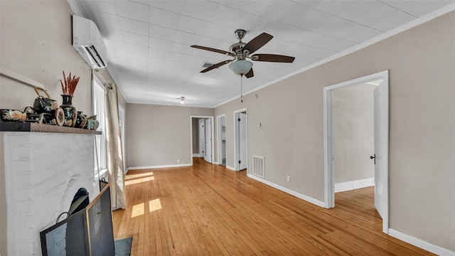 unfurnished living room featuring ceiling fan, a wall unit AC, light wood-type flooring, and visible vents