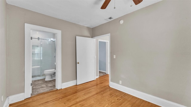 unfurnished bedroom featuring ceiling fan, light wood finished floors, baseboards, ensuite bathroom, and visible vents