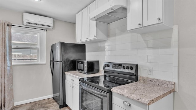 kitchen featuring baseboards, under cabinet range hood, a wall unit AC, appliances with stainless steel finishes, and backsplash