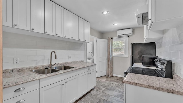 kitchen with a sink, decorative backsplash, an AC wall unit, and electric range