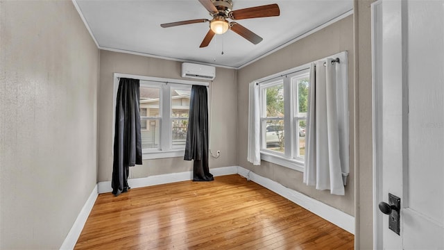 empty room with crown molding, baseboards, a wall mounted AC, and light wood-type flooring