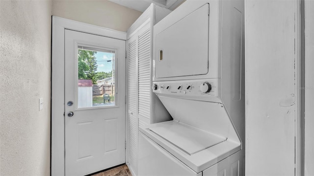 clothes washing area featuring laundry area and stacked washer / dryer