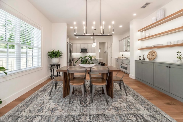 527 W Park St, Lakeland, FL 33803 - dining space with light wood finished floors, baseboards, a chandelier, and recessed lighting