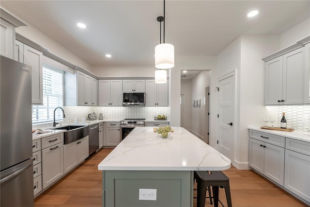 527 W Park St, Lakeland, FL 33803 - kitchen featuring stainless steel appliances, a sink, backsplash, a kitchen island, and light wood-type flooring