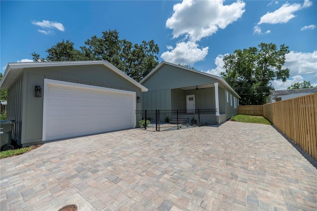 527 W Park St, Lakeland, FL 33803 - view of front facade with a garage, an outdoor structure, decorative driveway, and board and batten siding