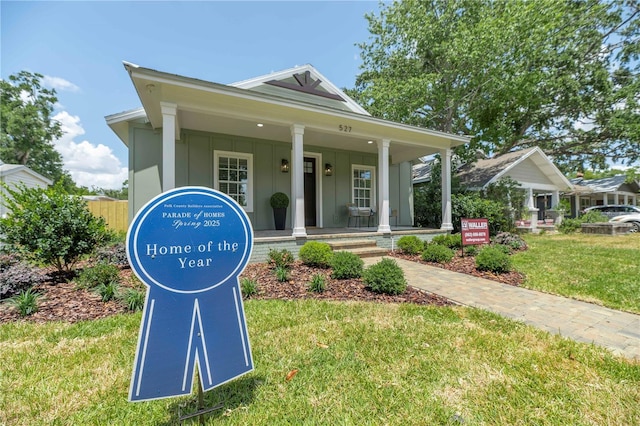 527 W Park St, Lakeland, FL 33803 - view of front of property featuring a front yard, board and batten siding, and covered porch