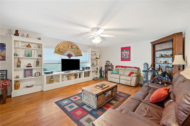 living area featuring a textured ceiling, a ceiling fan, and wood finished floors