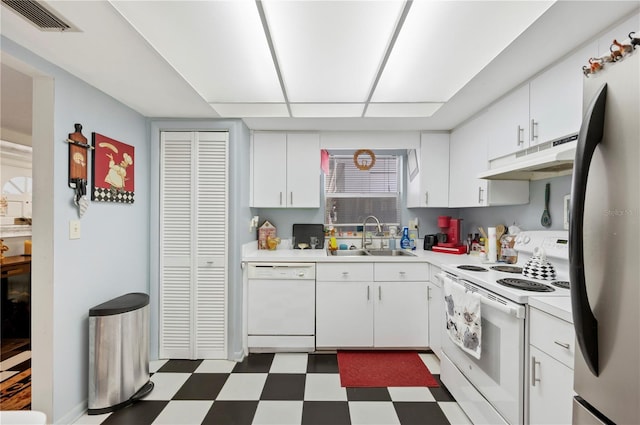 kitchen with visible vents, a sink, dark floors, under cabinet range hood, and white appliances