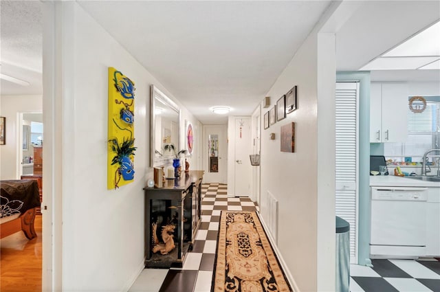 corridor with a sink and light floors