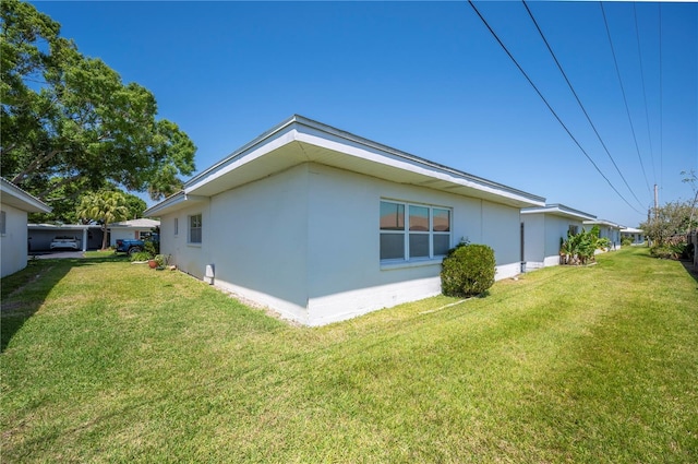 view of home's exterior with stucco siding and a yard