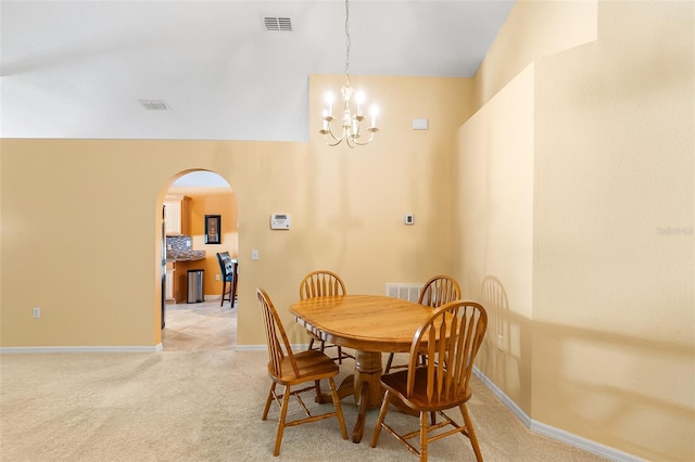 dining area featuring visible vents, arched walkways, baseboards, and a chandelier