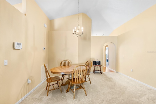 carpeted dining room featuring visible vents, arched walkways, vaulted ceiling, baseboards, and an inviting chandelier