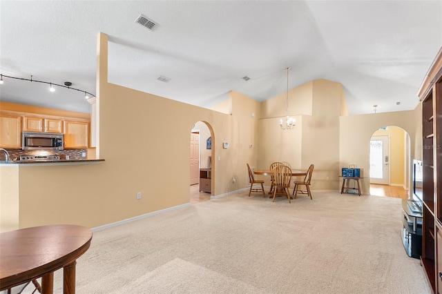 interior space featuring arched walkways, light colored carpet, visible vents, and a chandelier