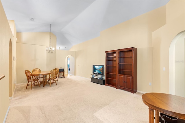 carpeted living room with arched walkways, high vaulted ceiling, a chandelier, baseboards, and visible vents