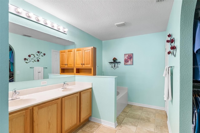 full bathroom featuring a textured ceiling, visible vents, a sink, and a bath