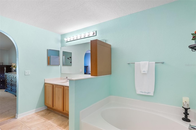 bathroom with vanity, tile patterned floors, a textured ceiling, and a bath