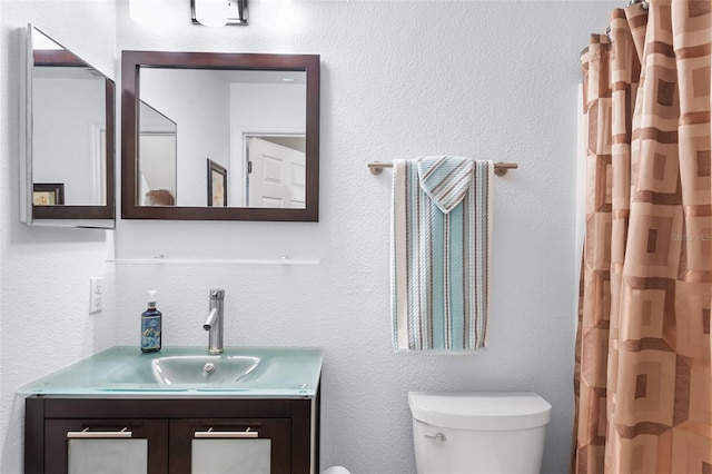 bathroom featuring toilet, curtained shower, and vanity