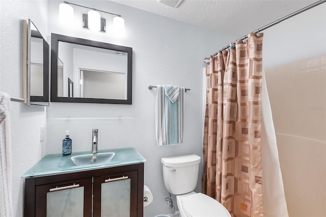 bathroom featuring toilet, a textured ceiling, curtained shower, and vanity