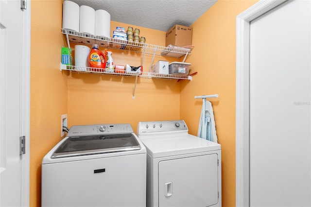 laundry room with laundry area, a textured ceiling, and washing machine and dryer