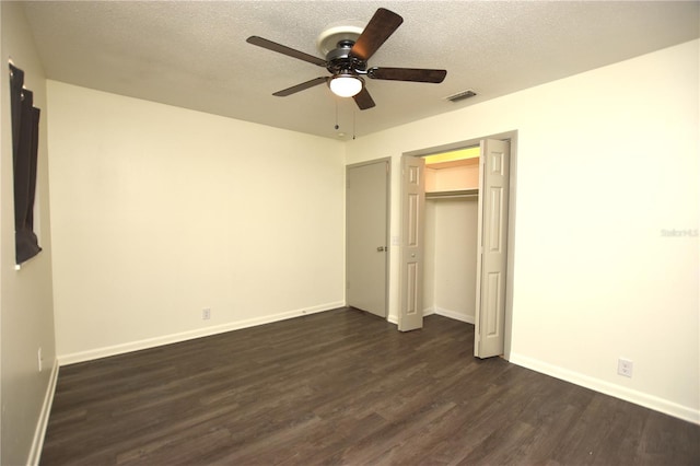 unfurnished bedroom featuring baseboards, a ceiling fan, dark wood finished floors, and visible vents
