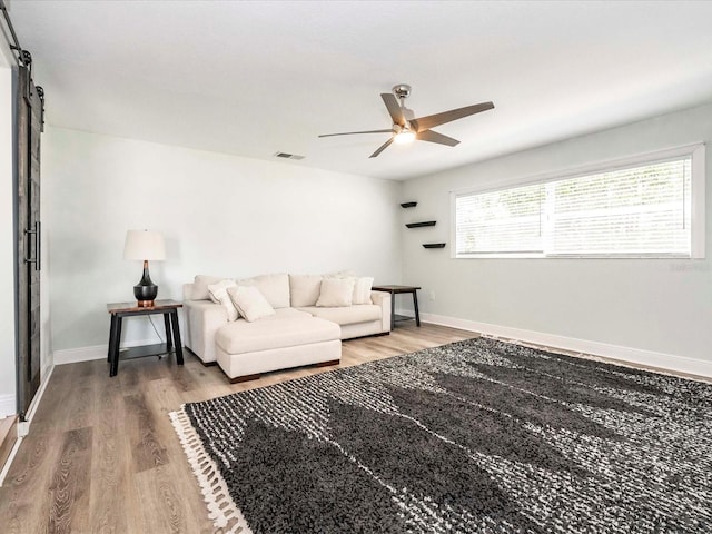 502 Duchess Dr, Lakeland, FL 33803 - living area with a barn door, a ceiling fan, baseboards, wood finished floors, and visible vents