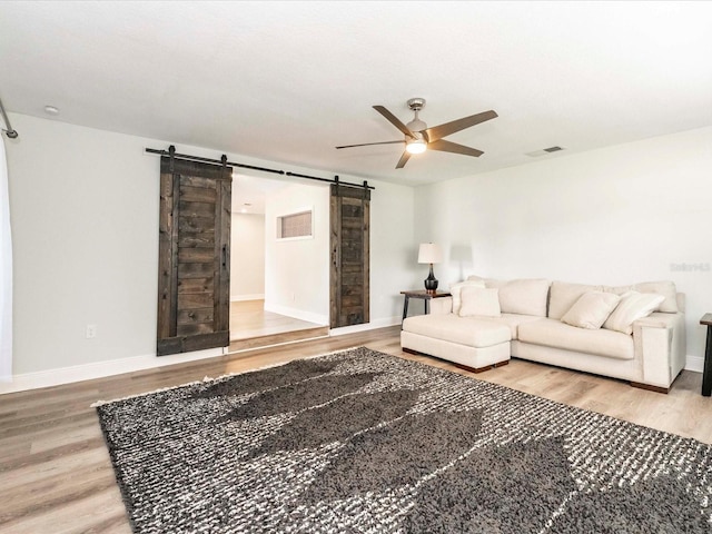 502 Duchess Dr, Lakeland, FL 33803 - living area with visible vents, ceiling fan, a barn door, and wood finished floors