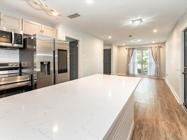 502 Duchess Dr, Lakeland, FL 33803 - kitchen featuring visible vents, light stone countertops, light wood-type flooring, recessed lighting, and stainless steel appliances