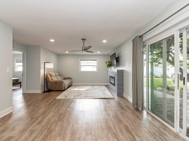502 Duchess Dr, Lakeland, FL 33803 - unfurnished living room featuring a fireplace, recessed lighting, baseboards, and light wood-type flooring