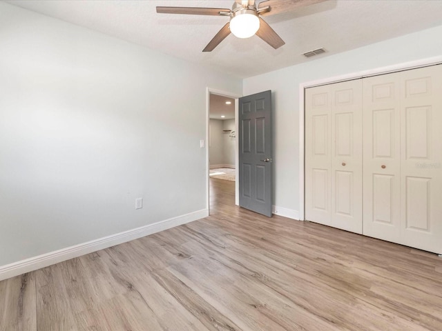 502 Duchess Dr, Lakeland, FL 33803 - unfurnished bedroom featuring visible vents, a closet, light wood-style floors, baseboards, and a ceiling fan