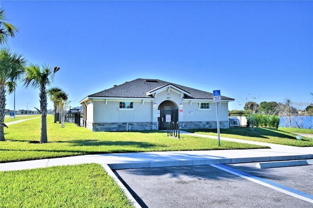 view of front of house featuring fence, stucco siding, uncovered parking, and a front lawn