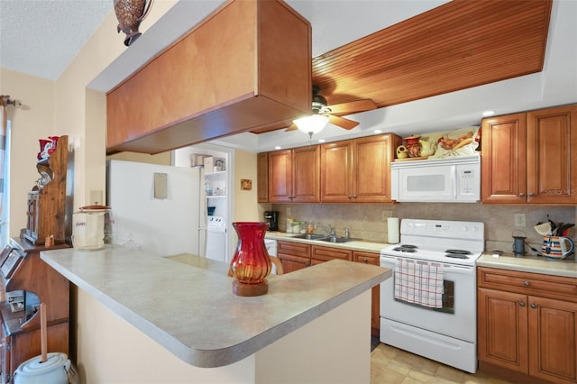 1130 N Lake Parker Ave Unit C321, Lakeland, FL 33805 - kitchen with light countertops, a sink, a peninsula, washer / dryer, and white appliances