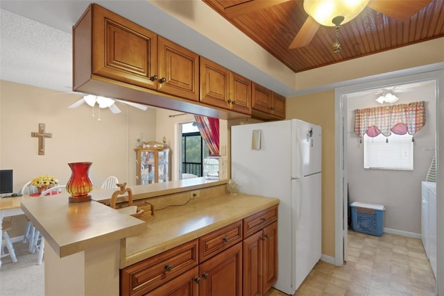 1130 N Lake Parker Ave Unit C321, Lakeland, FL 33805 - kitchen featuring brown cabinetry, freestanding refrigerator, a peninsula, ceiling fan, and light countertops