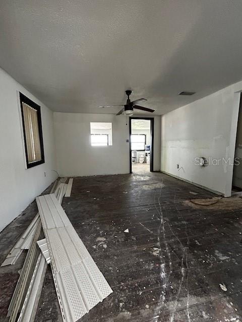 unfurnished living room featuring a ceiling fan