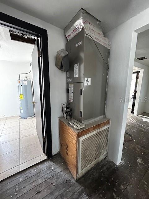 utilities featuring visible vents and electric water heater