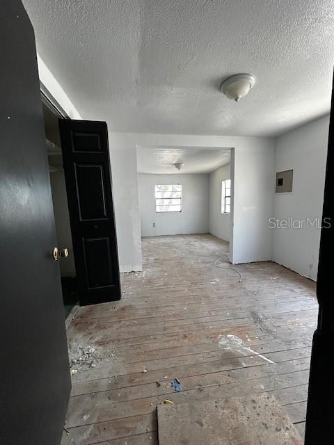 empty room featuring light wood-type flooring and a textured ceiling