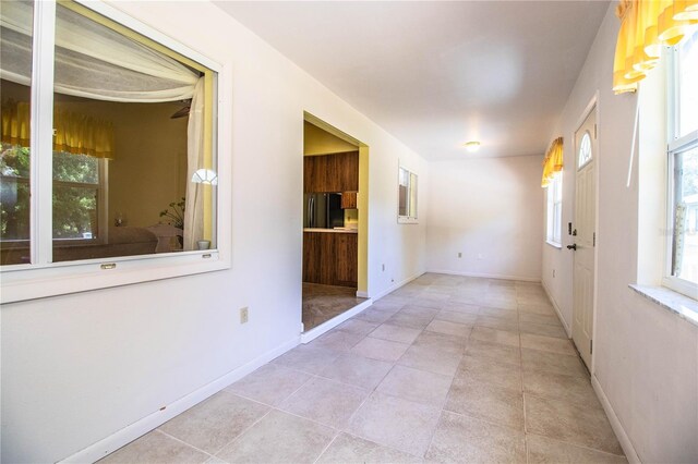 4976 Pleasant Hollow Trl, Lakeland, FL 33811 - hallway featuring a healthy amount of sunlight, tile patterned floors, and baseboards